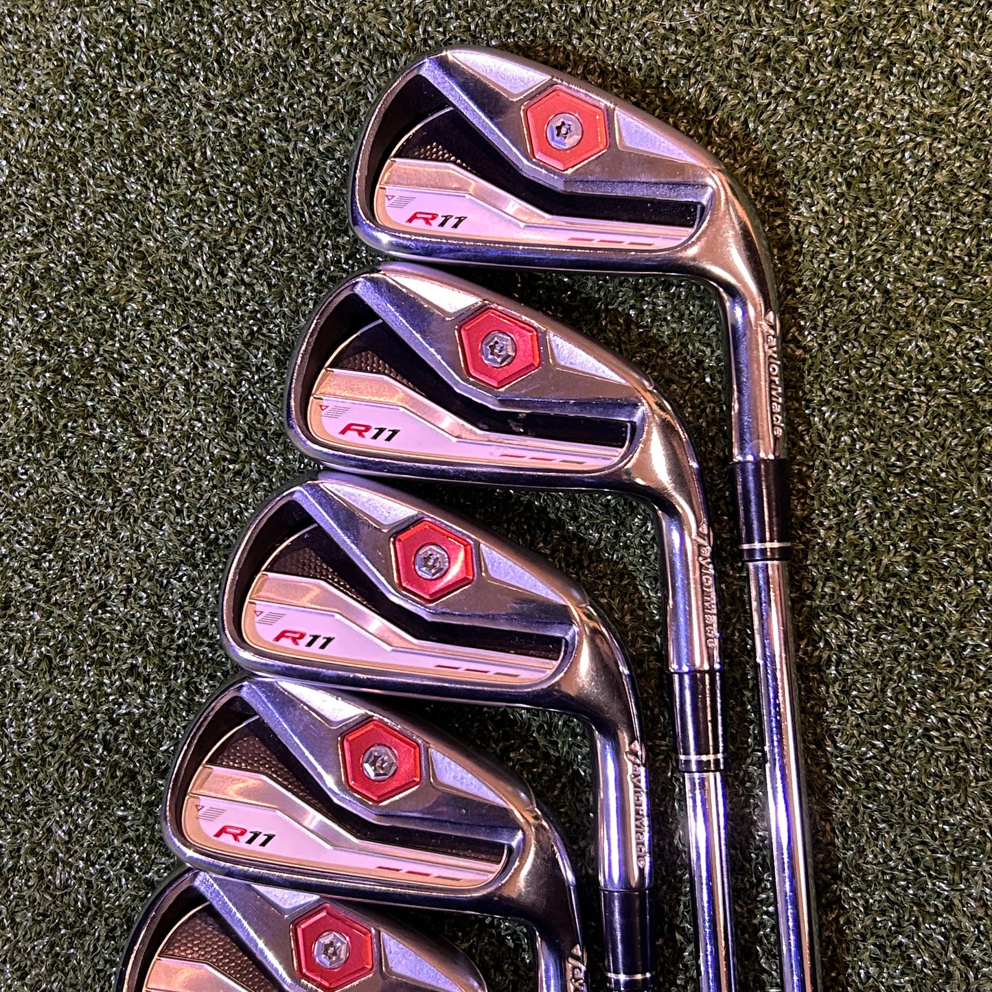 Set of golf clubs on a green grass background